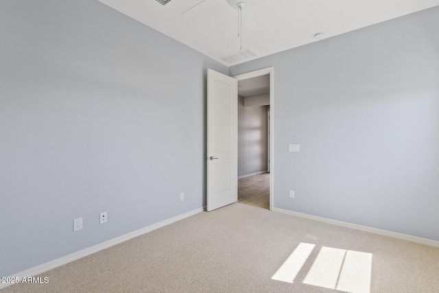 carpeted empty room featuring visible vents and baseboards