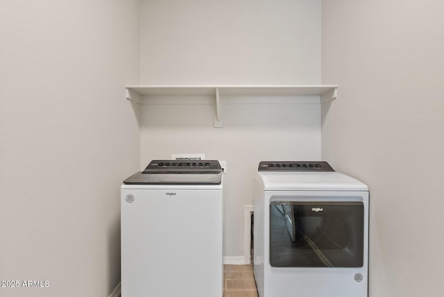 laundry area with baseboards, separate washer and dryer, and laundry area