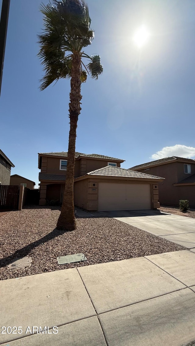 view of front of property with stucco siding, driveway, and an attached garage