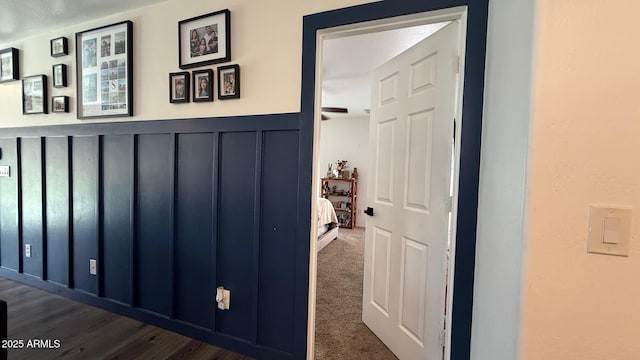 hall with a decorative wall and carpet floors