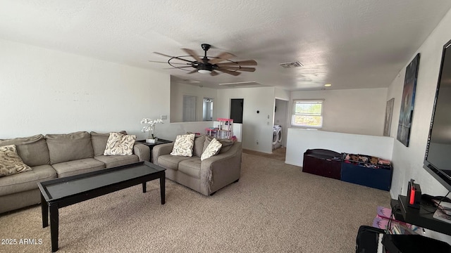 living area with visible vents, washer / dryer, ceiling fan, a textured ceiling, and carpet flooring