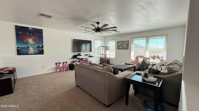 carpeted living room with baseboards, visible vents, a textured ceiling, and ceiling fan