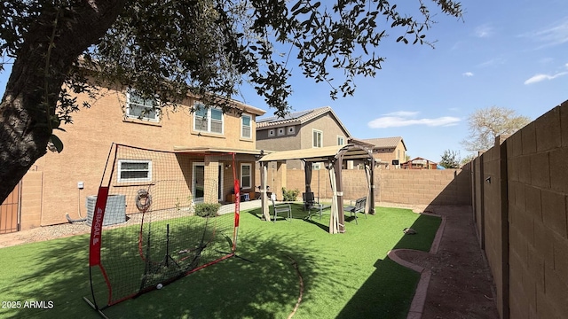 rear view of house with a yard, a fenced backyard, stucco siding, and a patio area