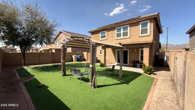 rear view of house with stucco siding, a pergola, a lawn, and a fenced backyard