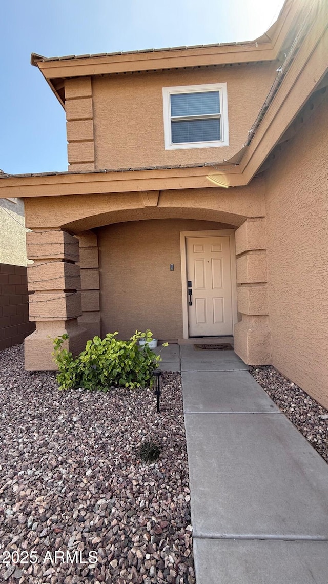 view of exterior entry with stucco siding