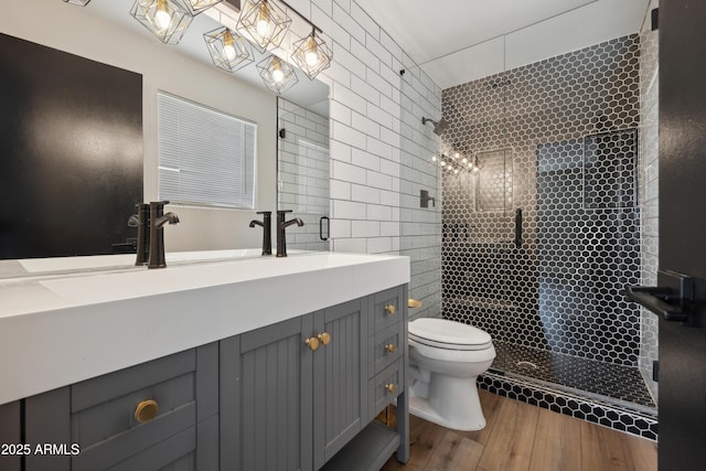 bathroom with hardwood / wood-style floors, vanity, an enclosed shower, and toilet