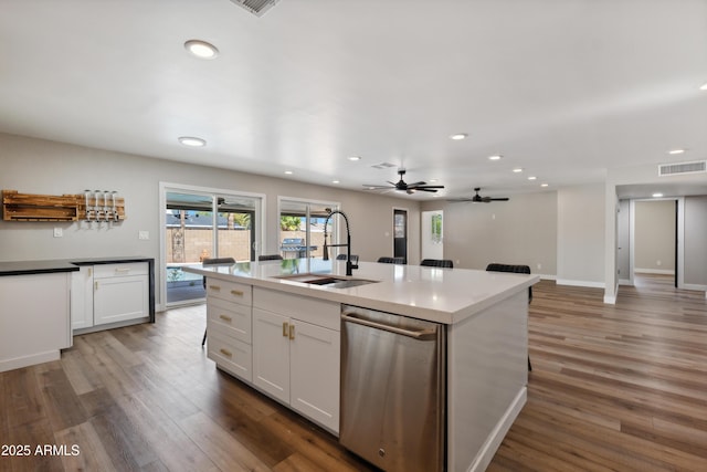 kitchen featuring dishwasher, sink, dark wood-type flooring, a kitchen island with sink, and white cabinets