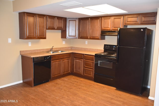 8124 N 33rd Dr, Phoenix, AZ 85051 - kitchen with black appliances, under cabinet range hood, light wood-style floors, visible vents, and a sink