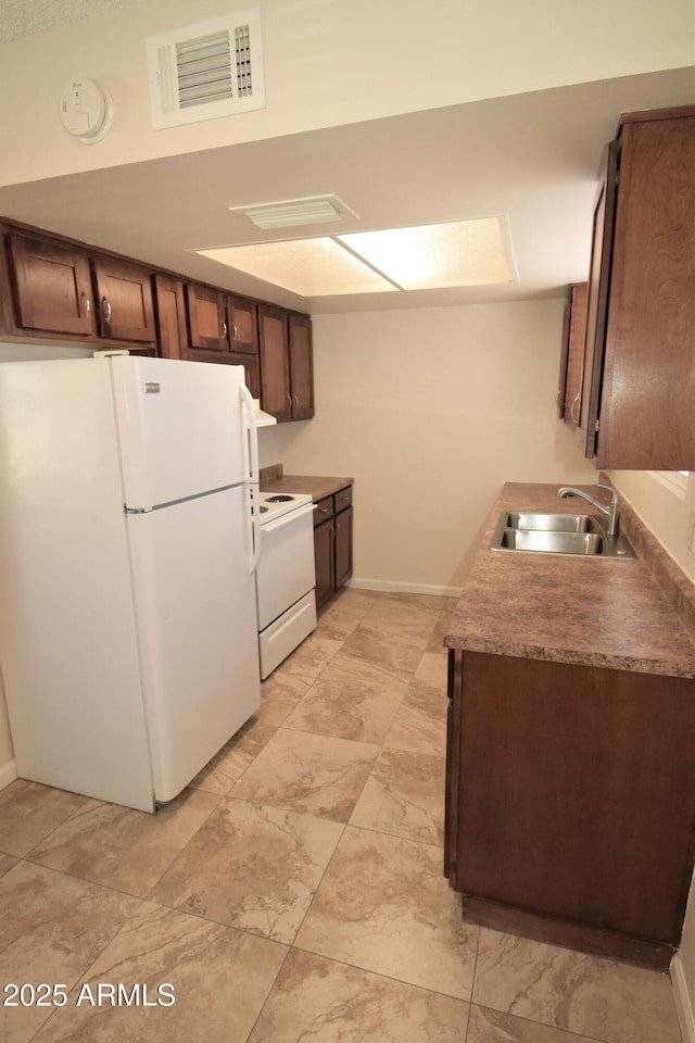8124 N 33rd Dr, Phoenix, AZ 85051 - kitchen featuring white appliances, dark brown cabinets, visible vents, a sink, and baseboards