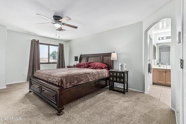 6422 W Range Mule Dr, Phoenix, AZ 85083 - bedroom with light colored carpet, baseboards, arched walkways, connected bathroom, and ceiling fan