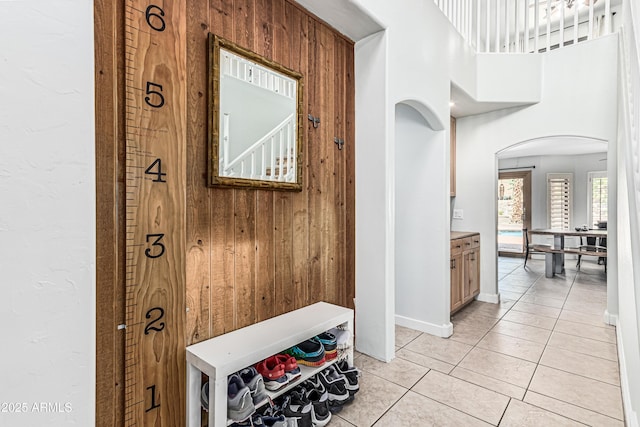 6422 W Range Mule Dr, Phoenix, AZ 85083 - hall featuring arched walkways, wood walls, light tile patterned floors, and baseboards