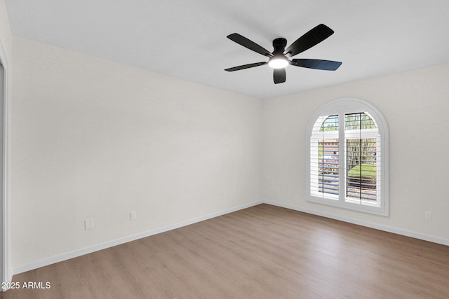 unfurnished room featuring wood finished floors, ceiling fan, and baseboards