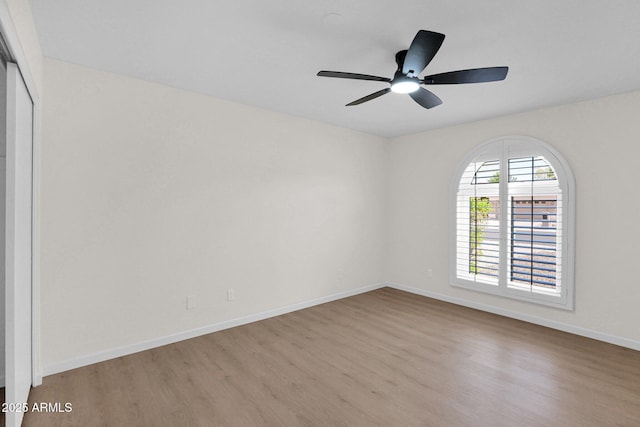 unfurnished room featuring wood finished floors, ceiling fan, and baseboards
