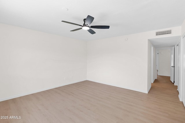 empty room with light wood-type flooring, a ceiling fan, and baseboards