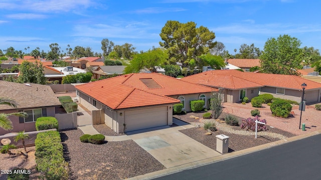 view of front of property featuring a gate, stucco siding, concrete driveway, a tiled roof, and a garage