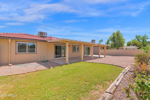 rear view of property featuring a patio, central AC, and a tile roof