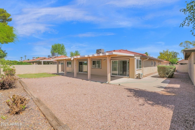 rear view of house featuring stucco siding, a patio area, and a fenced backyard