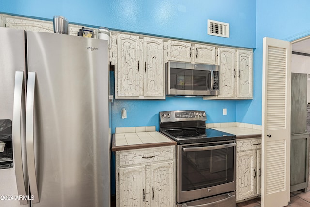 kitchen with tile counters and stainless steel appliances