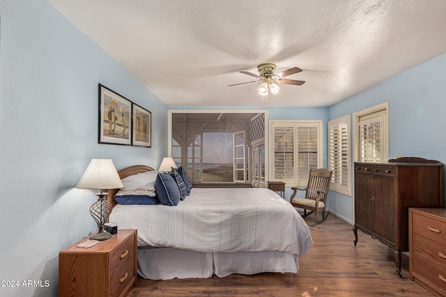 bedroom with ceiling fan, dark hardwood / wood-style floors, and a textured ceiling