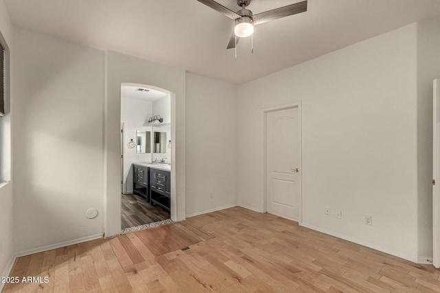 unfurnished bedroom with ensuite bath, ceiling fan, sink, and light hardwood / wood-style floors