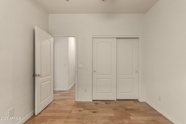 unfurnished bedroom with light wood-type flooring and a closet