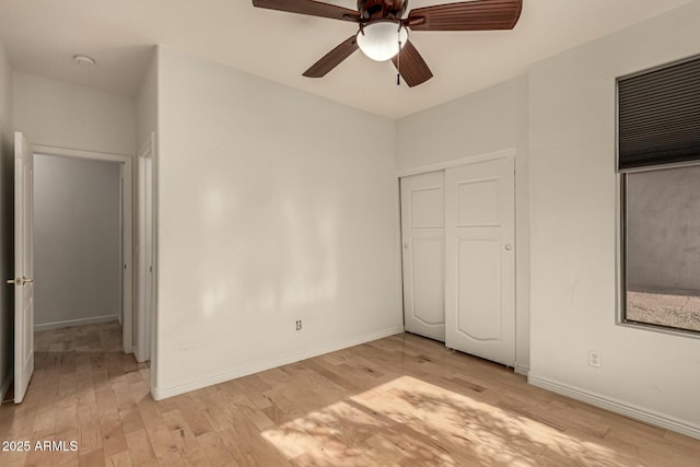 unfurnished bedroom featuring ceiling fan, light wood-type flooring, and a closet