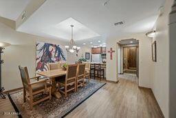 dining room featuring a notable chandelier, a tray ceiling, and wood finished floors