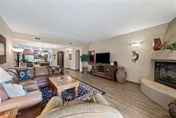 living room featuring a fireplace with raised hearth and an inviting chandelier