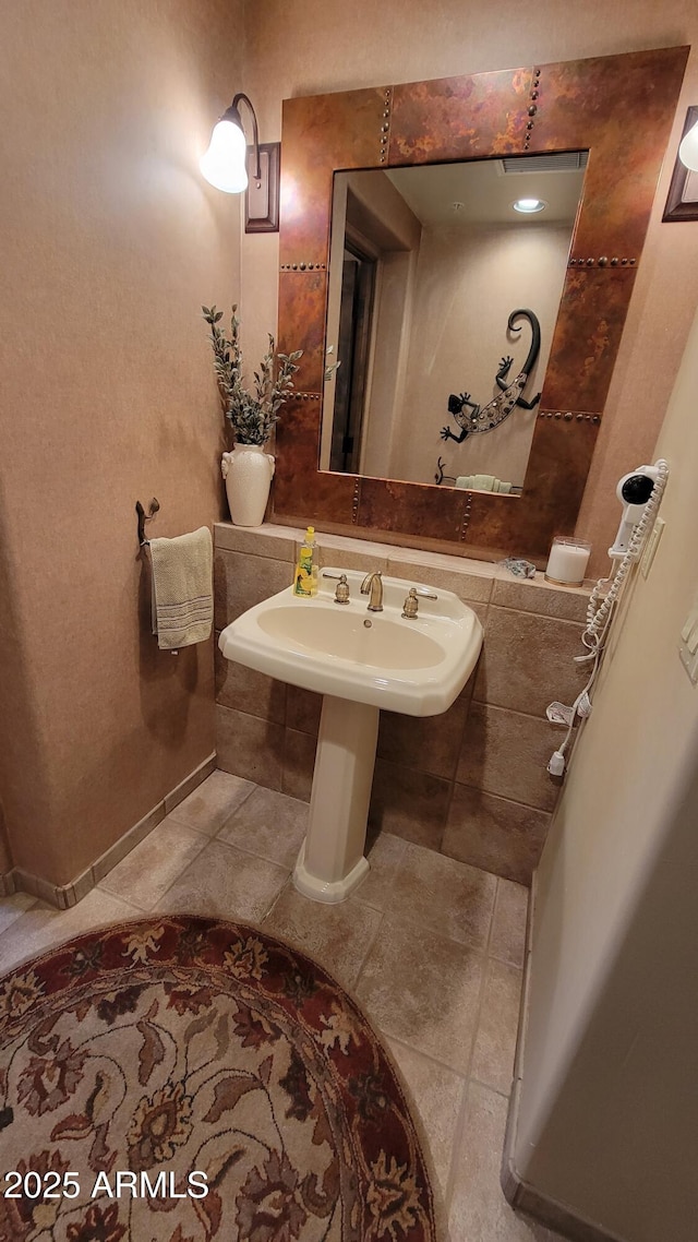 bathroom with baseboards, a sink, and tile patterned floors