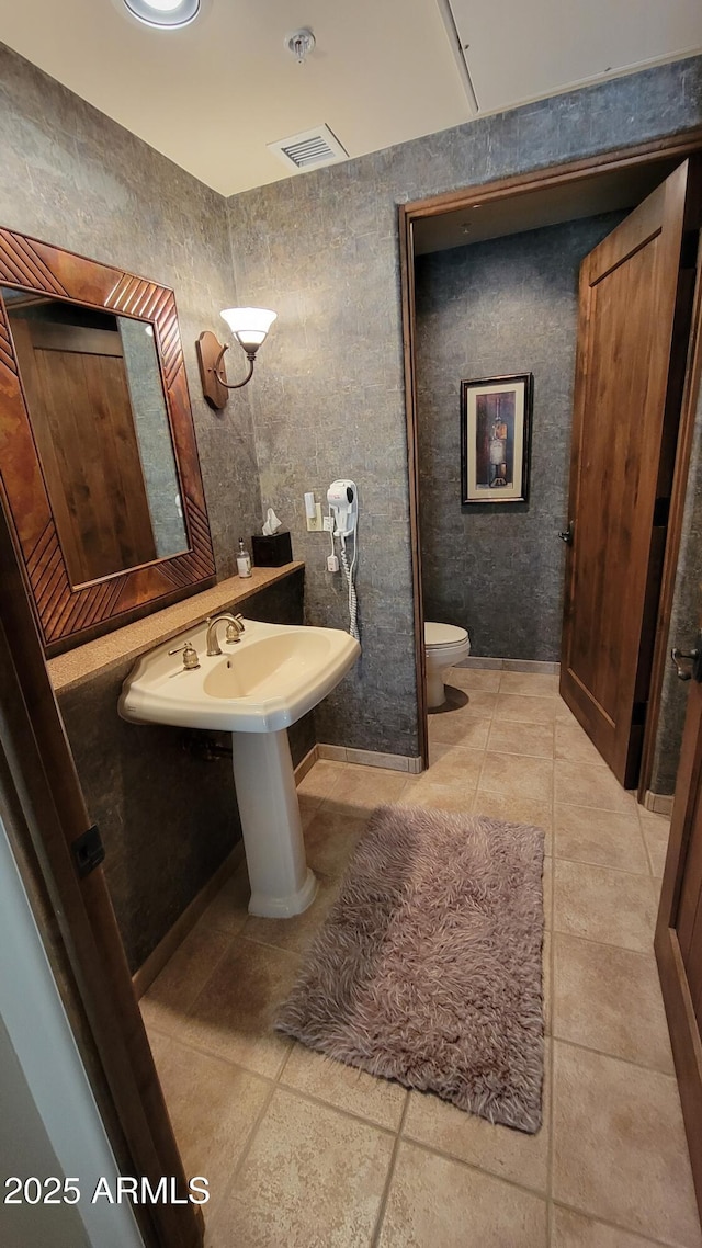 bathroom with tile patterned flooring, visible vents, and toilet