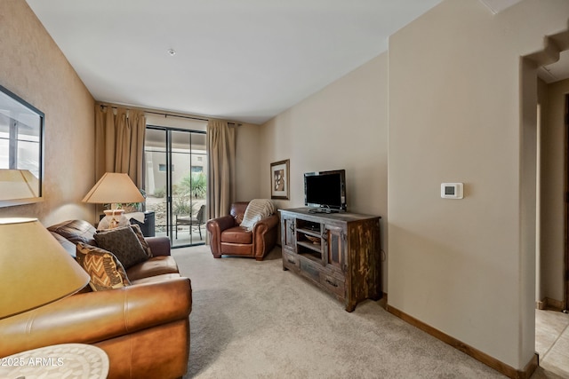 living room featuring light carpet and baseboards