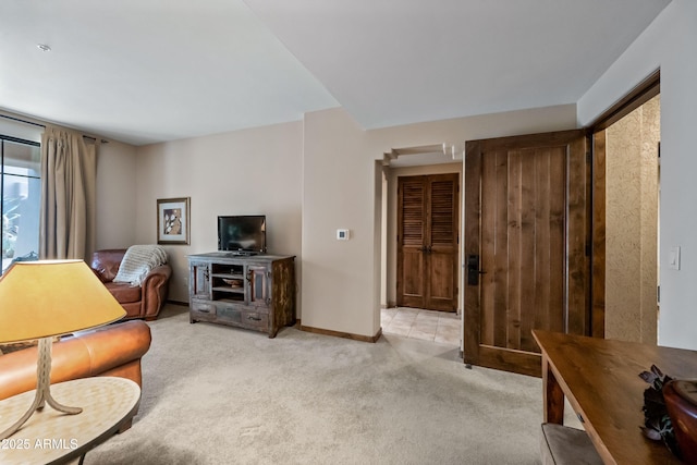 living area featuring baseboards and light colored carpet