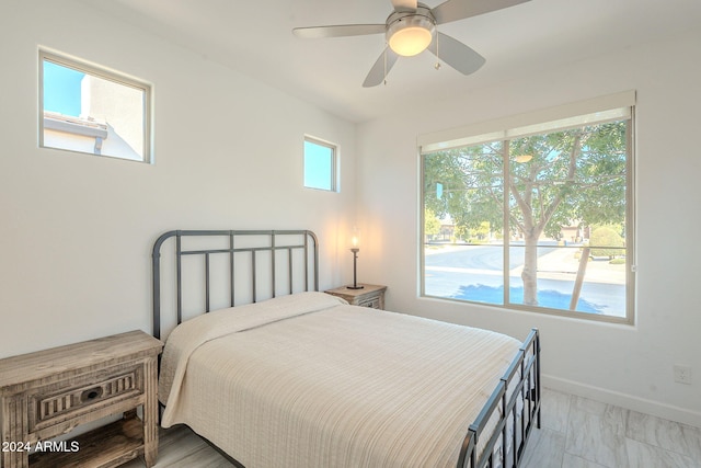 bedroom with ceiling fan and multiple windows