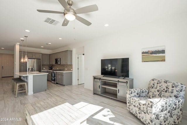 living room featuring light hardwood / wood-style flooring and ceiling fan