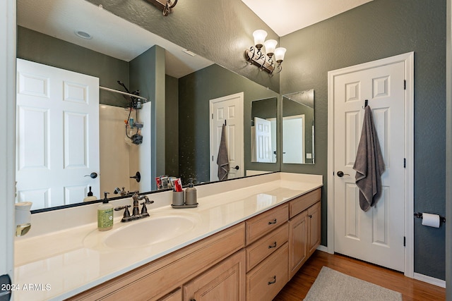 bathroom featuring hardwood / wood-style floors, vanity, and a chandelier