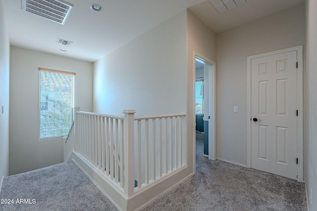 hallway featuring light colored carpet