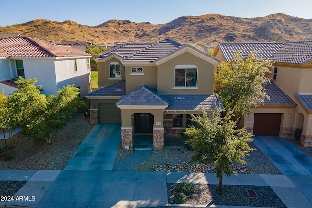 view of front facade with a mountain view, a porch, and a garage