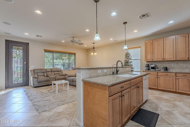 kitchen featuring decorative backsplash, sink, hanging light fixtures, and light brown cabinets