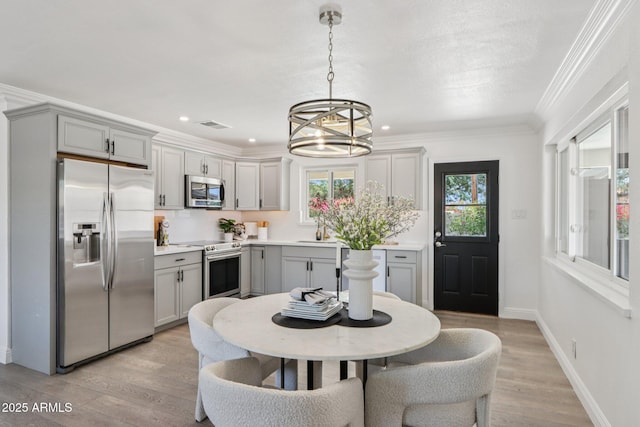 7049 E Latham St, Scottsdale, AZ 85257 - kitchen with appliances with stainless steel finishes, gray cabinets, a chandelier, crown molding, and a sink