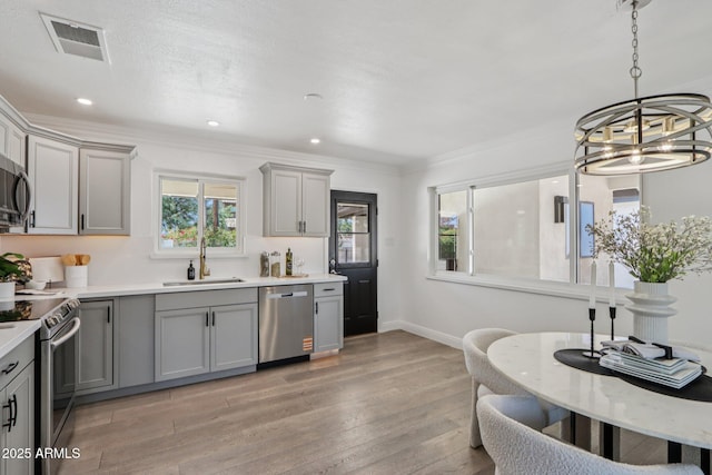 7049 E Latham St, Scottsdale, AZ 85257 - kitchen with gray cabinetry, appliances with stainless steel finishes, a sink, a chandelier, and light countertops