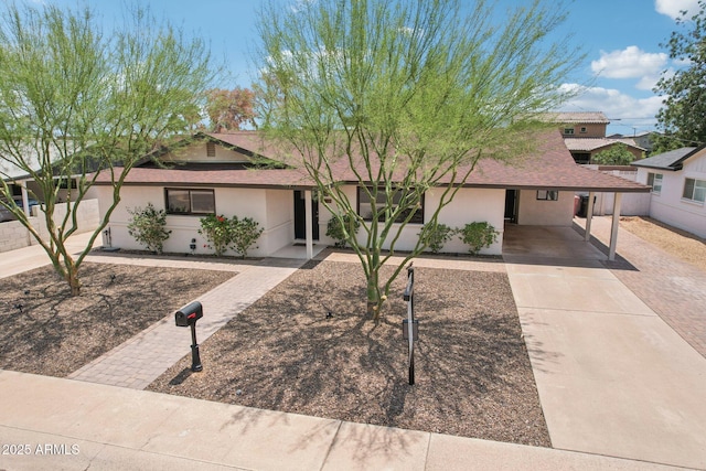 7049 E Latham St, Scottsdale, AZ 85257 - ranch-style house featuring concrete driveway, stucco siding, a carport, and a shingled roof