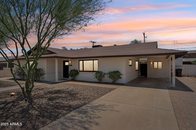 7049 E Latham St, Scottsdale, AZ 85257 - view of front of property with stucco siding, a carport, a shingled roof, and driveway