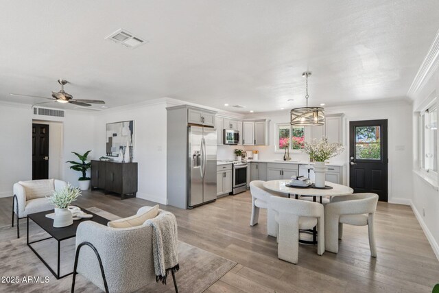 7049 E Latham St, Scottsdale, AZ 85257 - dining room with light wood-style flooring, ornamental molding, baseboards, ceiling fan, and a chandelier
