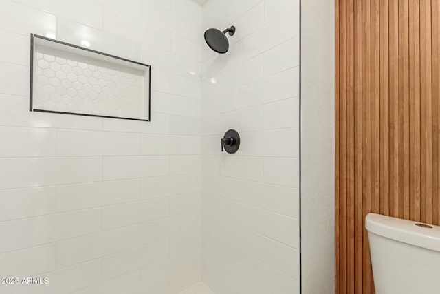 bathroom with tiled shower and toilet