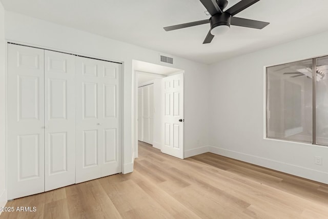 unfurnished bedroom featuring light wood-style floors, a closet, visible vents, and baseboards