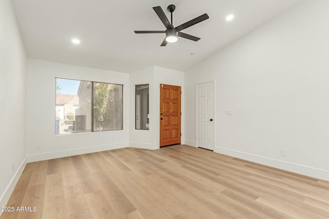 spare room featuring light wood finished floors, lofted ceiling, recessed lighting, a ceiling fan, and baseboards