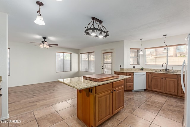 kitchen featuring sink, light tile patterned floors, dishwasher, ceiling fan, and a kitchen island