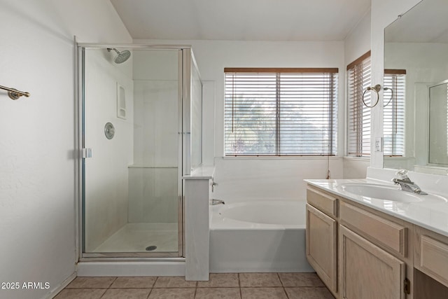 bathroom with tile patterned flooring, vanity, and plus walk in shower