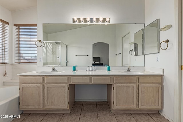 bathroom with vanity, tile patterned flooring, vaulted ceiling, and independent shower and bath