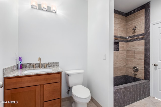 bathroom featuring tiled shower, vanity, toilet, and tile patterned flooring